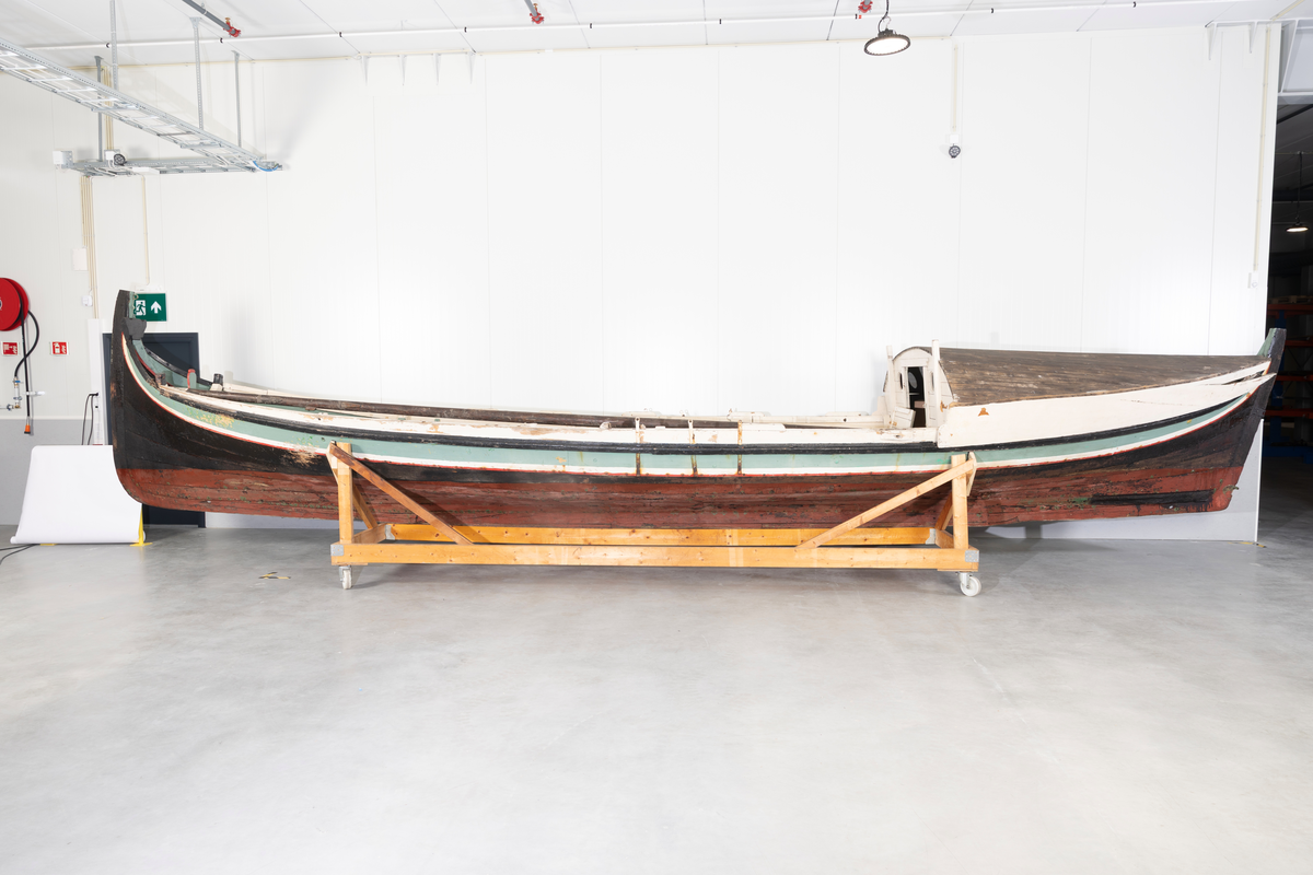 Åttring med løfting. Rødbrunt bunnstoff og tjæret skrog. Øverste bordgang har bredere grønt felt og smalere hvitt og rødt felt.