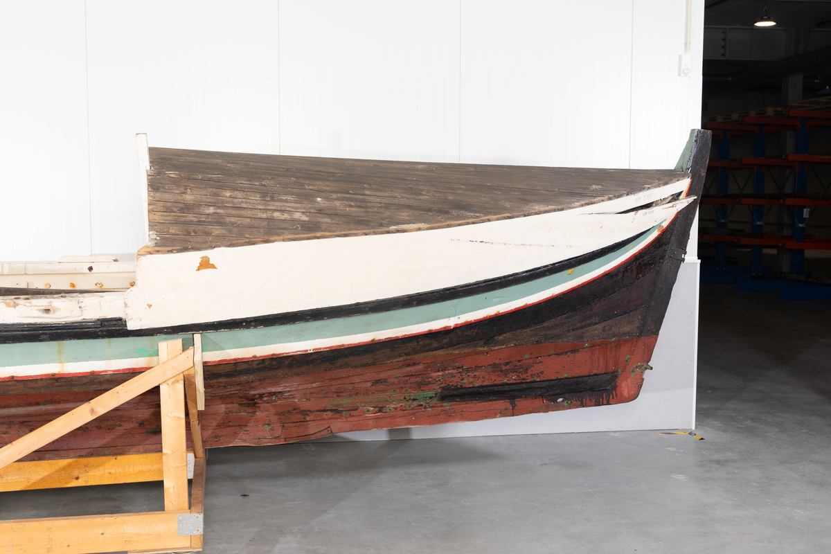 Åttring med løfting. Rødbrunt bunnstoff og tjæret skrog. Øverste bordgang har bredere grønt felt og smalere hvitt og rødt felt.