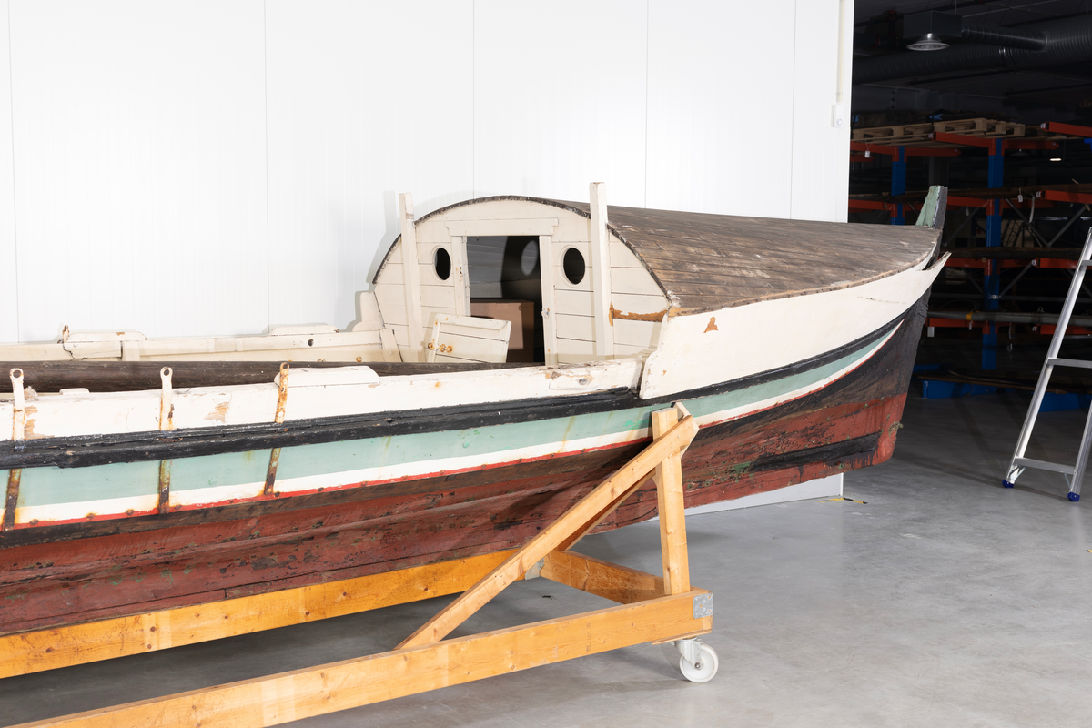 Åttring med løfting. Rødbrunt bunnstoff og tjæret skrog. Øverste bordgang har bredere grønt felt og smalere hvitt og rødt felt.