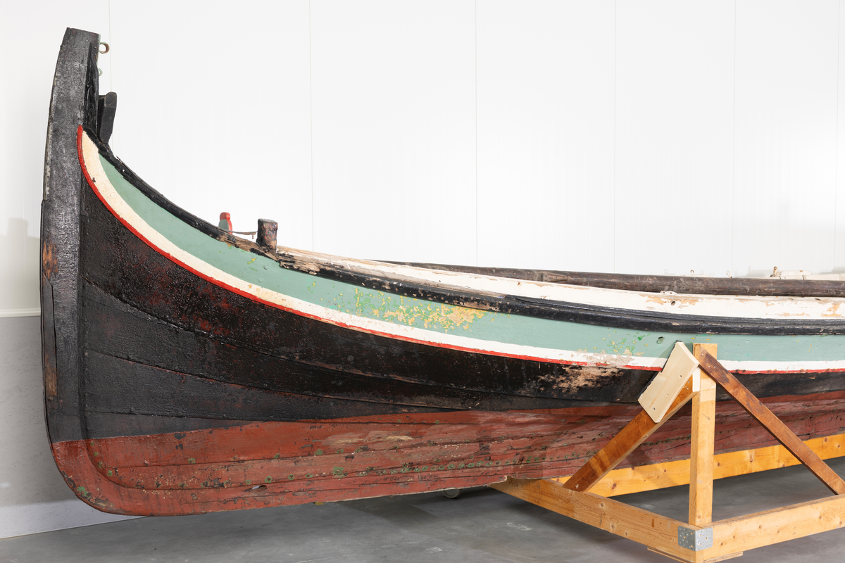 Åttring med løfting. Rødbrunt bunnstoff og tjæret skrog. Øverste bordgang har bredere grønt felt og smalere hvitt og rødt felt.