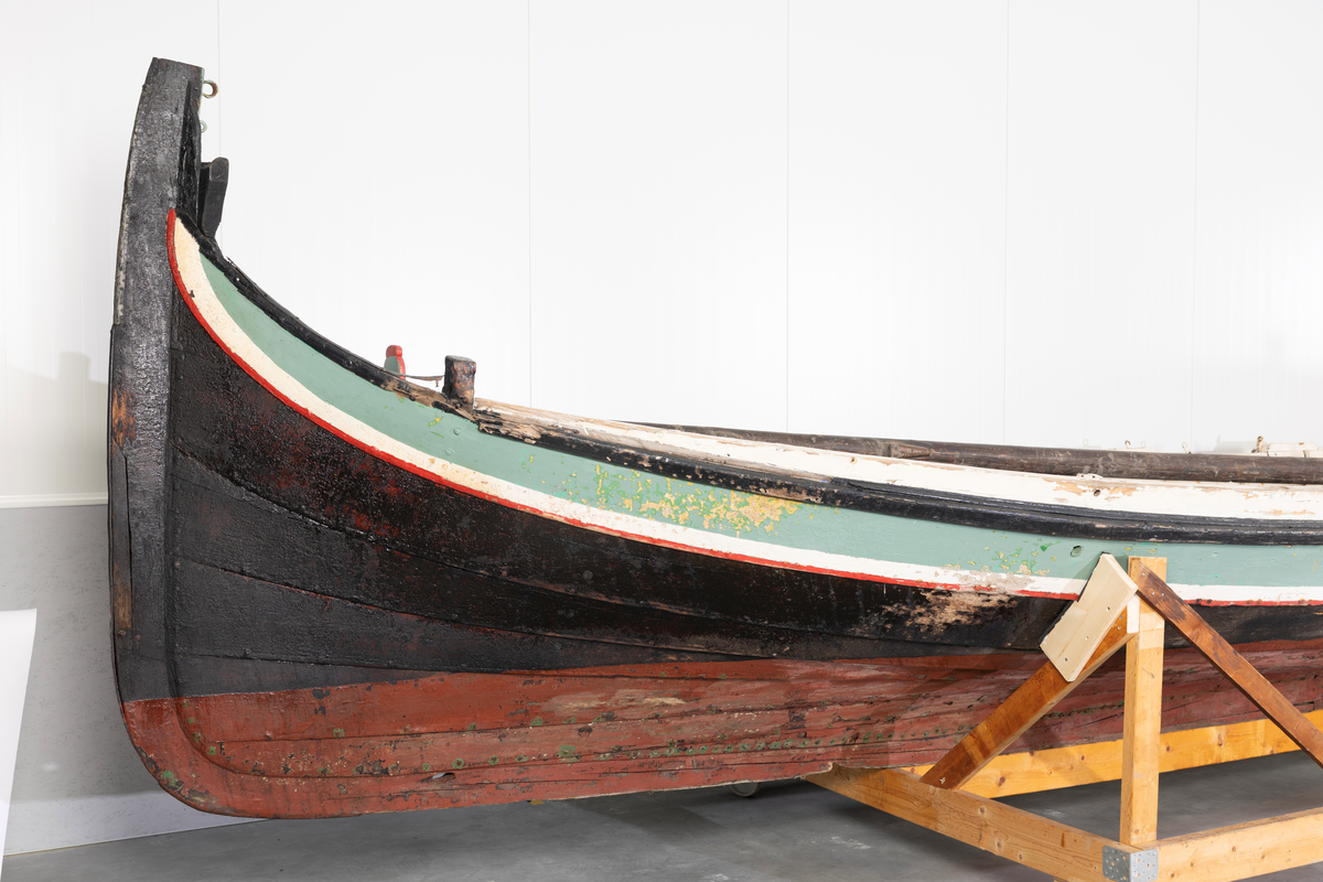 Åttring med løfting. Rødbrunt bunnstoff og tjæret skrog. Øverste bordgang har bredere grønt felt og smalere hvitt og rødt felt.