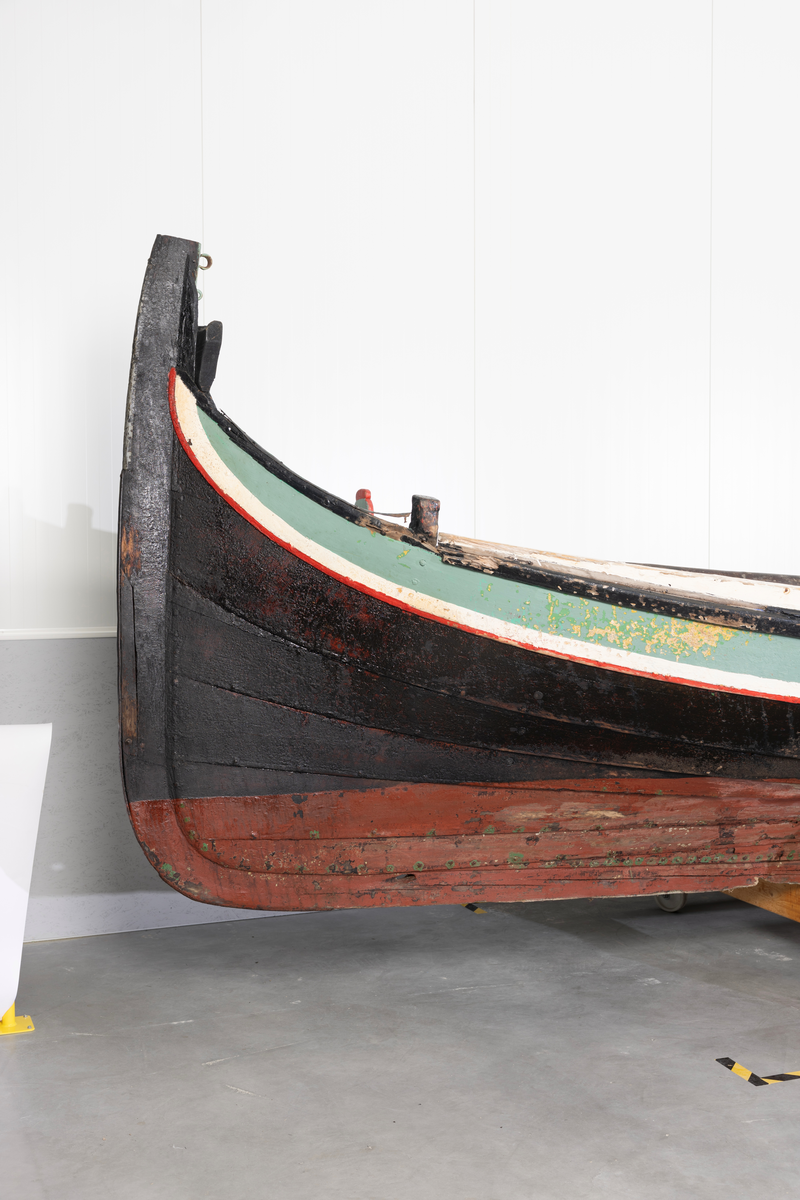 Åttring med løfting. Rødbrunt bunnstoff og tjæret skrog. Øverste bordgang har bredere grønt felt og smalere hvitt og rødt felt.