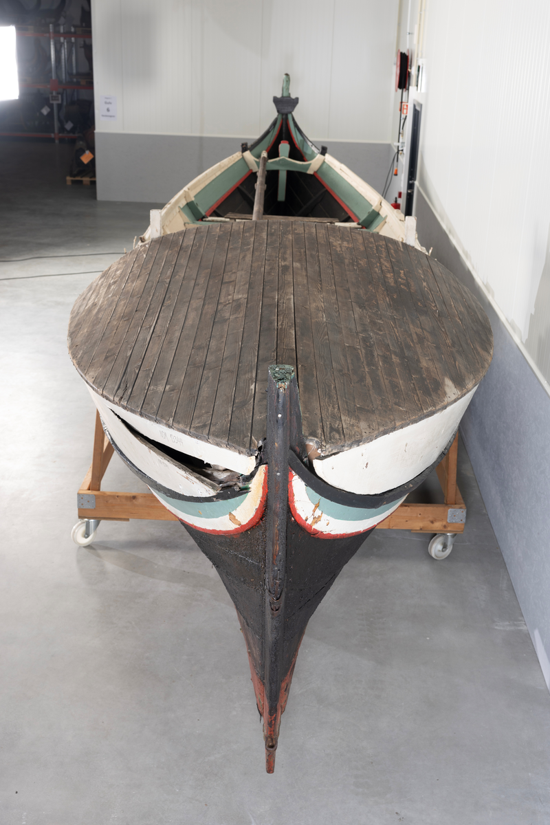 Åttring med løfting. Rødbrunt bunnstoff og tjæret skrog. Øverste bordgang har bredere grønt felt og smalere hvitt og rødt felt.