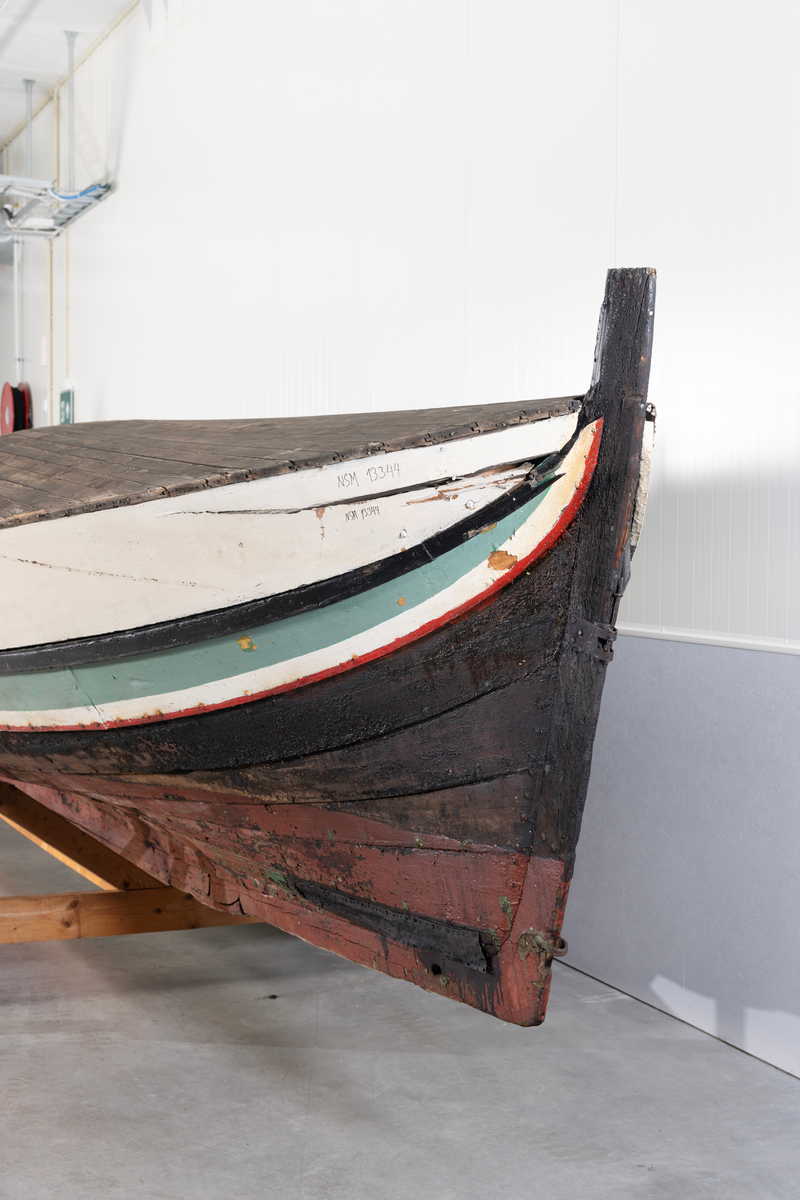 Åttring med løfting. Rødbrunt bunnstoff og tjæret skrog. Øverste bordgang har bredere grønt felt og smalere hvitt og rødt felt.