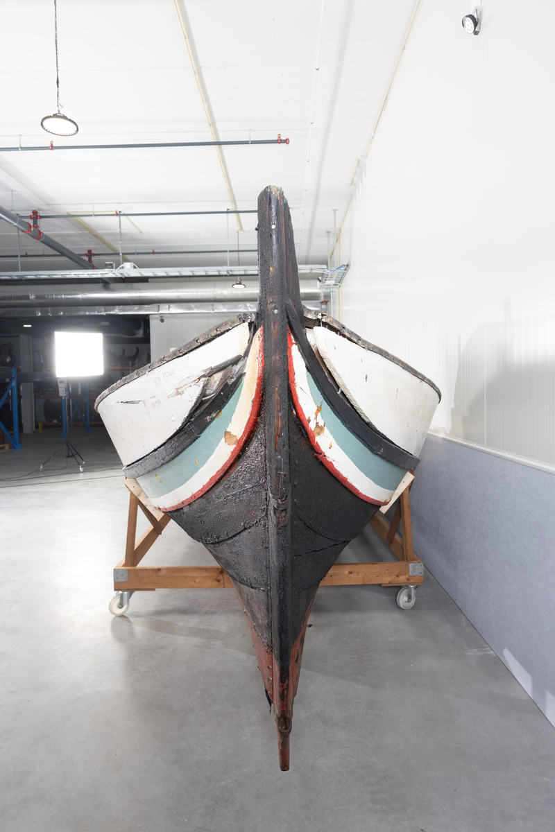 Åttring med løfting. Rødbrunt bunnstoff og tjæret skrog. Øverste bordgang har bredere grønt felt og smalere hvitt og rødt felt.