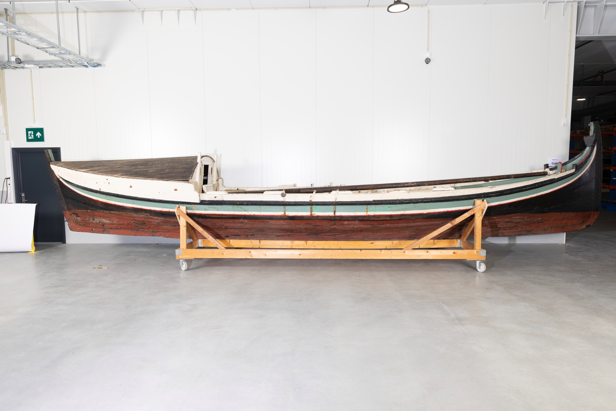 Åttring med løfting. Rødbrunt bunnstoff og tjæret skrog. Øverste bordgang har bredere grønt felt og smalere hvitt og rødt felt.