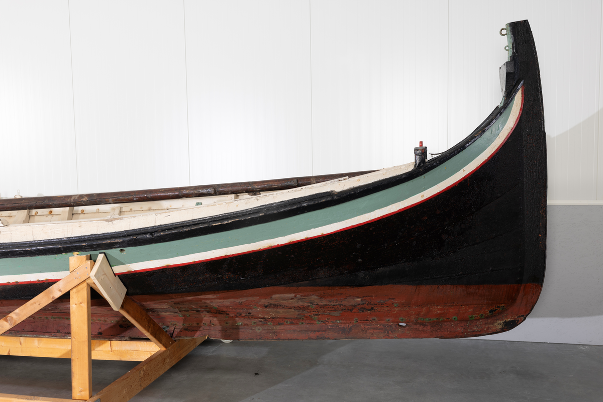 Åttring med løfting. Rødbrunt bunnstoff og tjæret skrog. Øverste bordgang har bredere grønt felt og smalere hvitt og rødt felt.