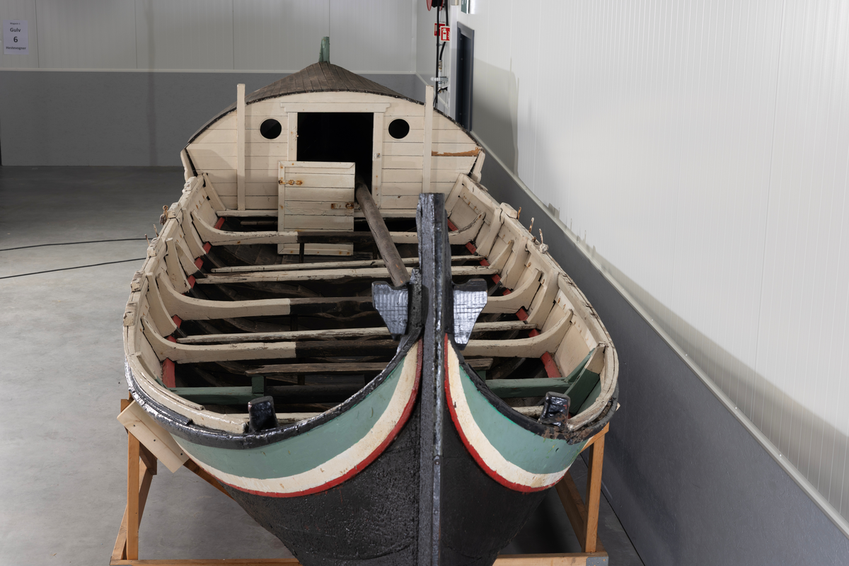 Åttring med løfting. Rødbrunt bunnstoff og tjæret skrog. Øverste bordgang har bredere grønt felt og smalere hvitt og rødt felt.