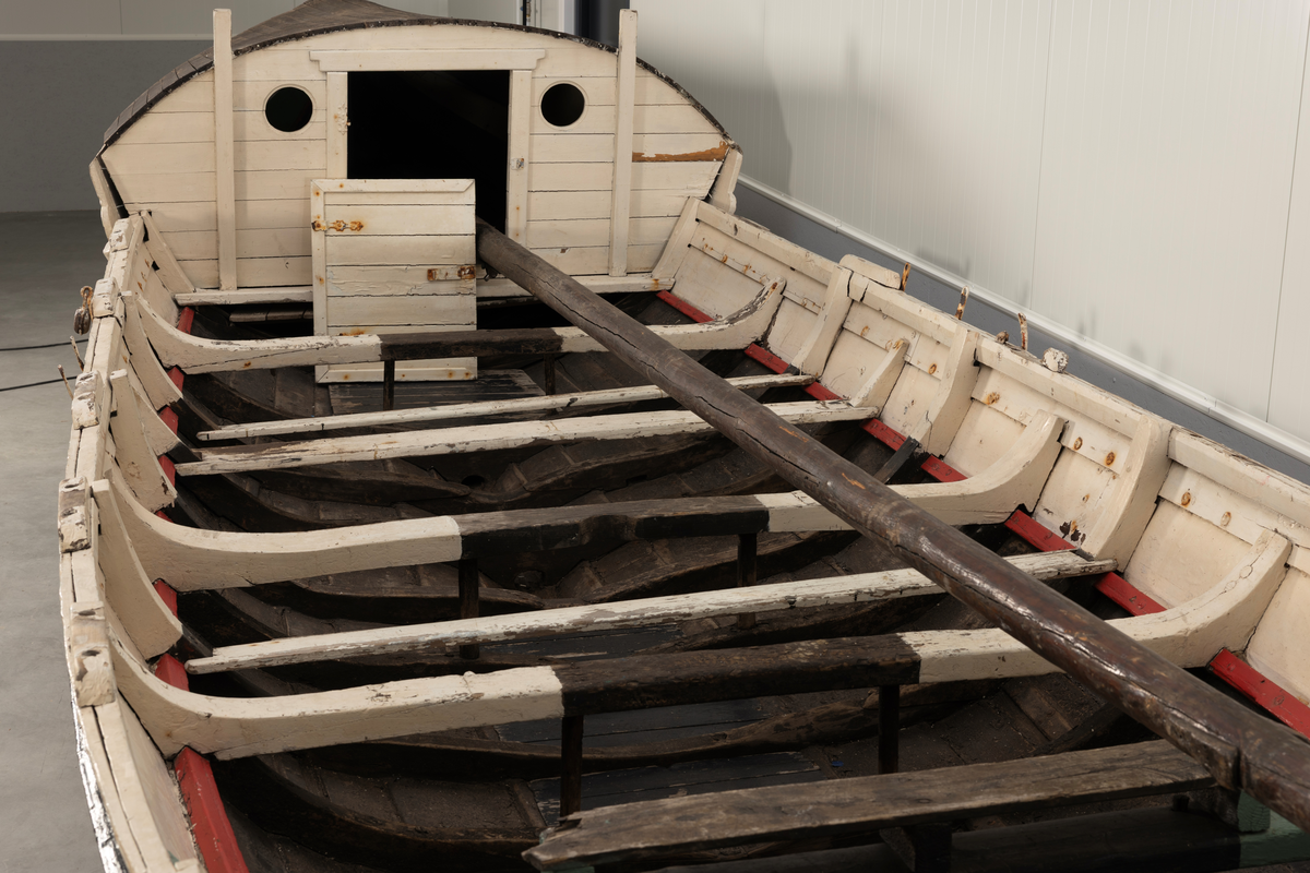 Åttring med løfting. Rødbrunt bunnstoff og tjæret skrog. Øverste bordgang har bredere grønt felt og smalere hvitt og rødt felt.