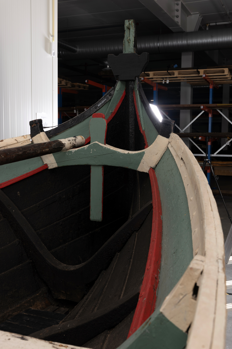 Åttring med løfting. Rødbrunt bunnstoff og tjæret skrog. Øverste bordgang har bredere grønt felt og smalere hvitt og rødt felt.