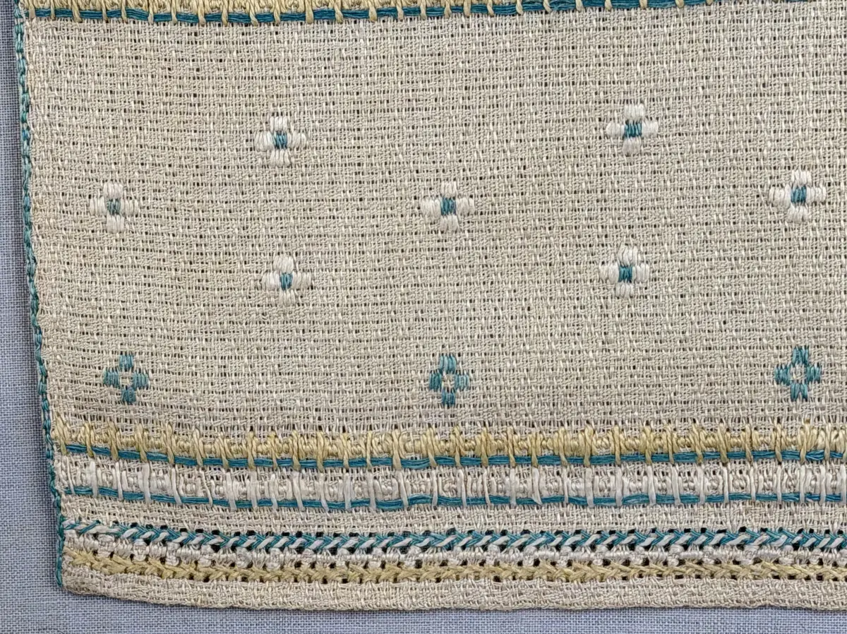 Löpare gjord av linneväv i sålldräll och broderi utfört med lingarn i plattsöm, flätsöm, trädstygn samt myrgång med tre kaststygn emellan. 
Långsidorna är kantade med efterstygn och duken har 6mm breda fållar runt om och raka hörn, som är sydda med smygstygn. 