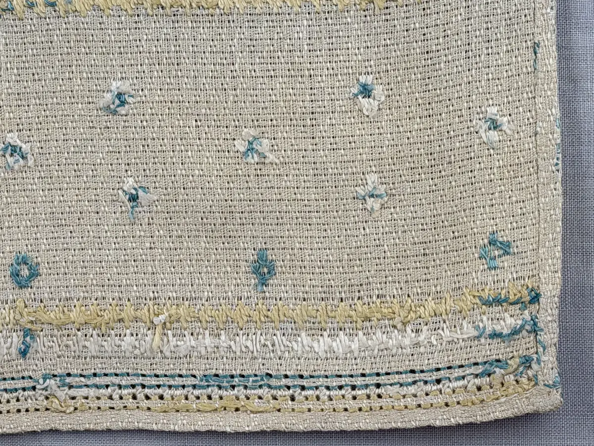 Löpare gjord av linneväv i sålldräll och broderi utfört med lingarn i plattsöm, flätsöm, trädstygn samt myrgång med tre kaststygn emellan. 
Långsidorna är kantade med efterstygn och duken har 6mm breda fållar runt om och raka hörn, som är sydda med smygstygn. 