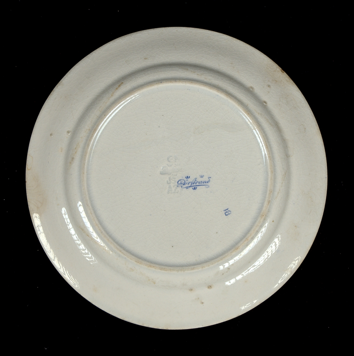 Prydnadsfat av flintgods med tryckt motiv i blått. Längs brämet löper texten: "MINNE FRÅN UTSTÄLLNINGEN I HALMSTAD 1912". I fatets spegel avbildas Norreport i Halmstad, samt texten: "JAC.ERICSONS PLANTSKOLA och BLOMSTERAFFÄR HALMSTAD". Undersidan är stämplad "Rörstrand".

Glasyr krackelerad.