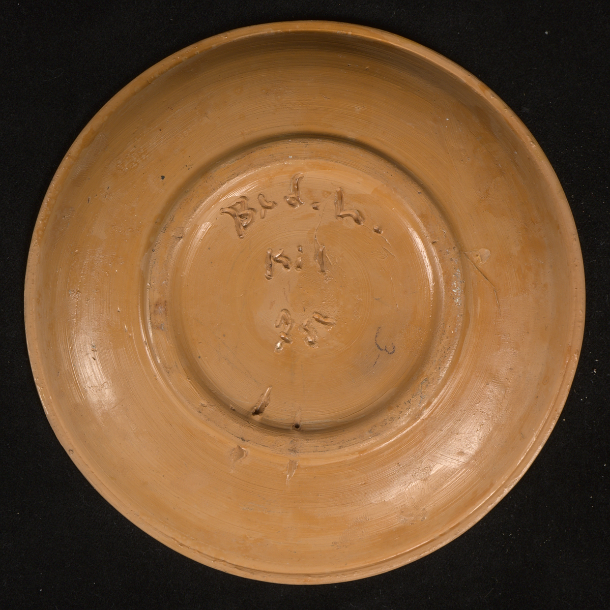 Prydnadsfat av lergods med handmålad blomsterdekor och texten "Varberg" i spegeln. Måleriet signerat: "IKL". Fatet är runt och svagt skålformat med låg kant. Tydliga drejspår samt fingeravtryck. Fatet bär en genomskinlig, mjölktonad glasyr, som ligger ovanpå dekoren. På undersidan av fatet finns en upphöjd fotring försedd med två hål för väggupphängning.

Signatur och årtal på undersidan: ”B(?)d.h. KIL. 75”. Även siffran ”3” skriven i blyerts.