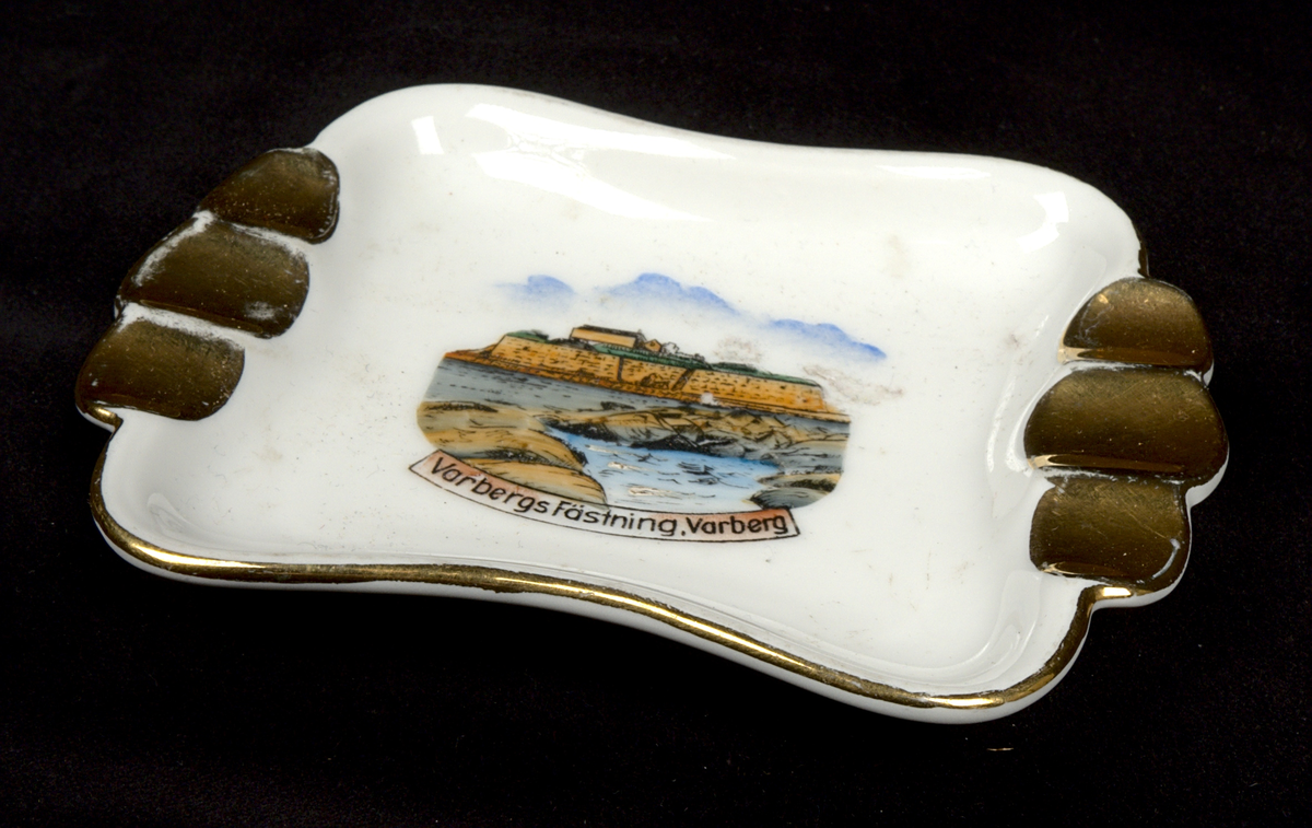 Askfat i porslin. Rektangulär form med svängda långsidor och tre guldglaserade urtag vid vardera kortsida, för placering av rökverk. I fatets mitt ett tryckt färgmotiv föreställande Varbergs fästning samt texten: "Varbergs fästning, Varberg".

På fatets undersida finns två stämplar: "Seltmann Weiden Bavaria" (grönt) och (?) "Hand painted Germany".