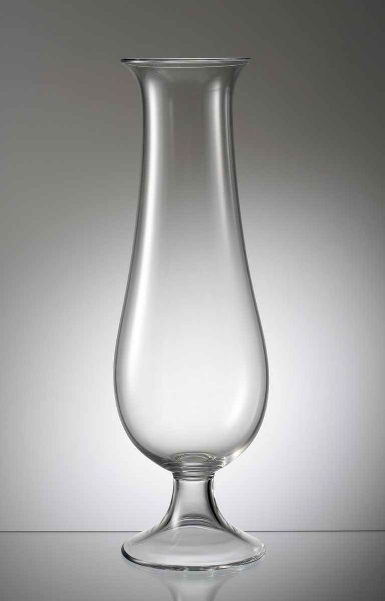 Hög vas på fot. Närmast droppformad kupa med utsvängd mynning. Hög klockformad fot.
Formgivare: Nils Landberg.