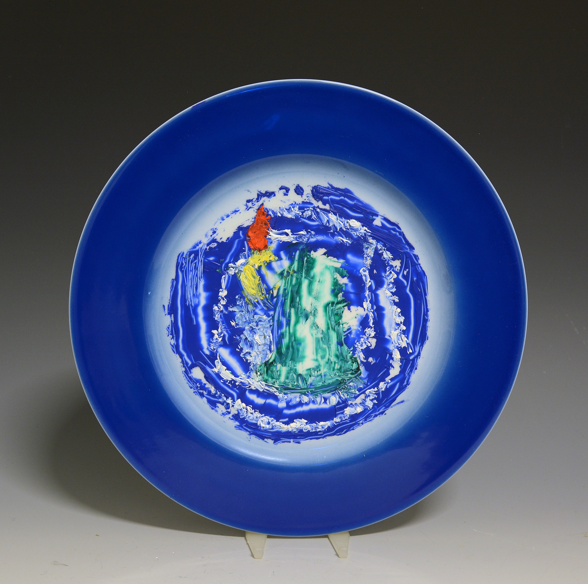 Fat av porselen med hvit glasur. Dekorert med nonfigurativt motiv i blått, grønt, gult og rødt. 

Dekor etter motiv av Jakob Weidemann