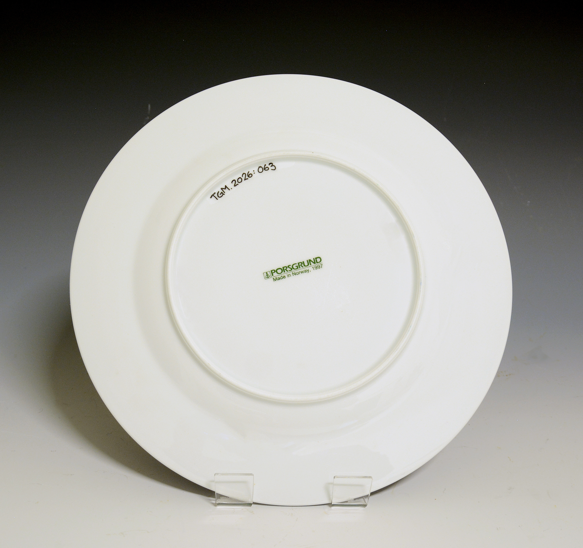 Fat av porselen med hvit glasur. Dekorert med nonfigurativt motiv i blått, grønt, gult og rødt. 

Dekor etter motiv av Jakob Weidemann