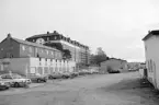 Längs vad som skulle komma att läggas ut som Kaptensgatan i Linköping 1992. Stadens trängregemente var sedan 1987 nedlagt och marken med utvalda byggnader stod nu mitt i förvandling mot ett nytt bostadsområde. Den stora byggnaden i bildens fond inrymde tidigare logement men byggdes nu om till bostäder.