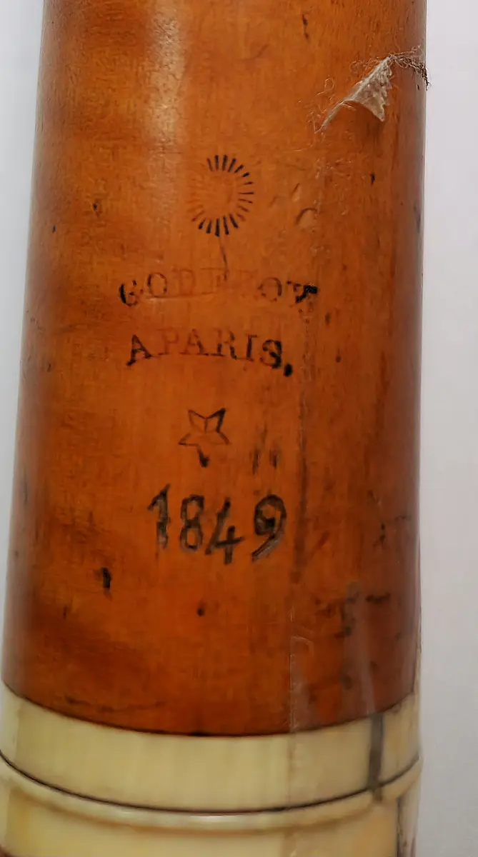 Tvärflöjt i buxbom med elfenbensringar. 5 delar. Konisk form och något krökt. Sprucket päron. 1 klaff med kullagring och rund platta.