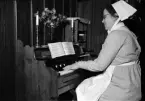 Kvinna spelar orgel, Uppsala 1947