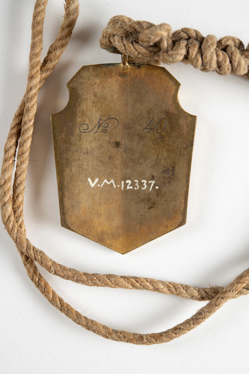 På baksidan ingraverat No. 40, Naturlig storlek, Teckning i orginal.
Hängande i ett snöre.