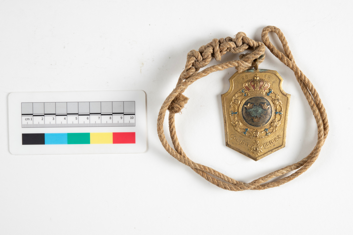 På baksidan ingraverat No. 40, Naturlig storlek, Teckning i orginal.
Hängande i ett snöre.