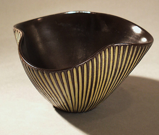 Rund treflikig skål av keram. sgraffito dekor, halvmatt svart glasyr, samt gul i skårorna på utsidan. Stämplad  UE Abg (=Ingrid Atterberg).UE SWEDEN. Pappersetikett med texten Upsala - Ekeby samt krona.