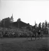 Idrottstävlingar på Värendsvallen, 1944.
Löpning för herrar. Gunder Hägg i täten. I bakgrunden syns hedersläktaren.