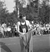 Idrottstävlingar på Värendsvallen, 1944.
Gunder Hägg tar på träningsoverallen efter löpning.