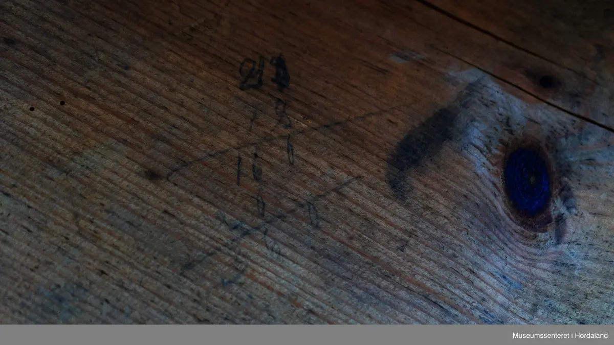 Bukseformer i tre. Kan brettes i to, Ble antakeligvis brukt til å tørke og forme ferdige underbukser før salg. Den har to hengsler.
Har to innfelte forsterkninger i tre, på tvers.