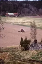 Medföljande text: "Traktor med vält på fält".