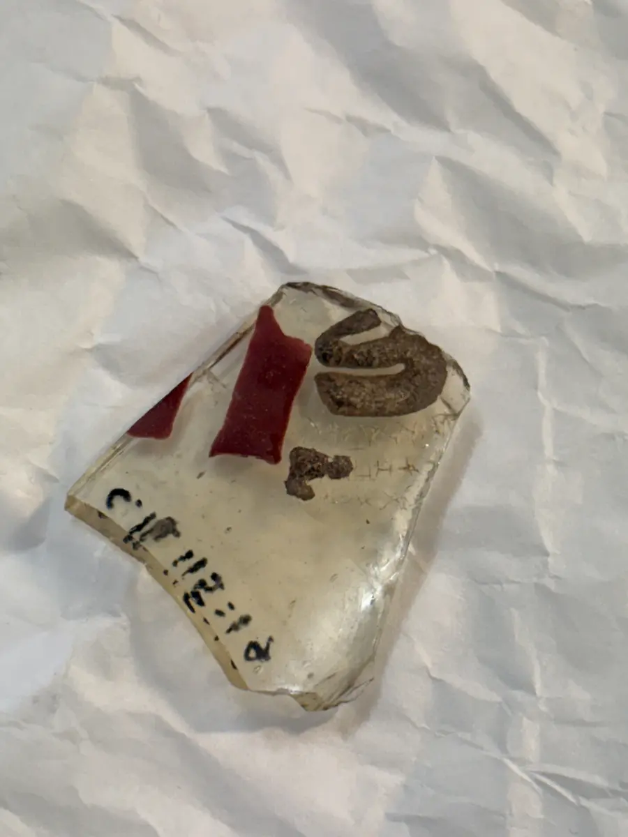 
Spår av röda, blå och vita färger, överst arabisk inskrift. 
Hela ytan är graverad med slingor, som troligtvis varit täckta med guld, och ur denna bakgrund framträder tre mänskliga figurer vars kläder varit dels emaljerade i rött och vitt, dels belagda med guld, som vid fyndet redan fallit bort. På glasets brätte finns tre vapensköldar som antyder att ägaren varit emir och mellan dessa en arabisk inskrift, som lytt: "Ära vare vår herre, sultanen, konungen , den rättvise, den vise, ära vare hans seger." Samma inskrift upprepas omedelbart under brättet. 

Nuvarande höjd 19, övre diam. C:a 11, nedre diam. C:a 6 cm. Inskrift översatt till svenska: "ära vare vår herre, sultanen, konungen, den rättvise, den vise, ära vare hans seger". 