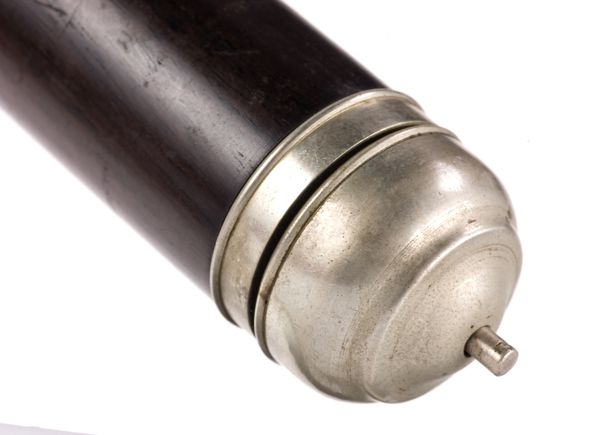 Tvärflöjt i mörkt trä med silverringar. 5 delar. Konisk form. Något krökt. Nedersta ringen saknas. 8 klaffar med kullagring och runda plattor, varav 1 klaff saknas. Sprickor i munstycke och päron. Nedre mellanstycke sprucket och amatörmässigt lagad.