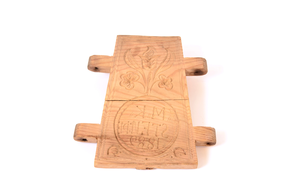 Gran, skåret. Fire sider, hver side trapesformet, skåret i et stykke og avstivet med stående labanker. To av sidene er skåret med to tapper på hver side med hull i. På de to andre, er skåret fire rektangulære hull (spalter), et i nærheten av hvert hjørne, som tappene passer inn i. Tappene settes inn i spaltene, og holdes på plass med sprosser. Sprossene mangler. I øvre kant på en av sidene er det kilt inn tilsammen tre tapper til feste for formens lokk ("tak"?). En tapp og lokket mangler. Skåret dekor på hver side.