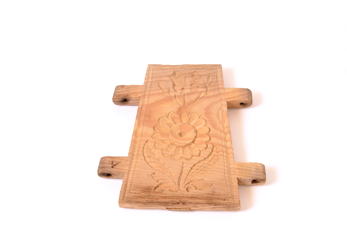 Gran, skåret. Fire sider, hver side trapesformet, skåret i et stykke og avstivet med stående labanker. To av sidene er skåret med to tapper på hver side med hull i. På de to andre, er skåret fire rektangulære hull (spalter), et i nærheten av hvert hjørne, som tappene passer inn i. Tappene settes inn i spaltene, og holdes på plass med sprosser. Sprossene mangler. I øvre kant på en av sidene er det kilt inn tilsammen tre tapper til feste for formens lokk ("tak"?). En tapp og lokket mangler. Skåret dekor på hver side.