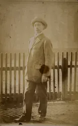 Portrett av mann foran stakittgjerde. 
Kan være Andreas Kris