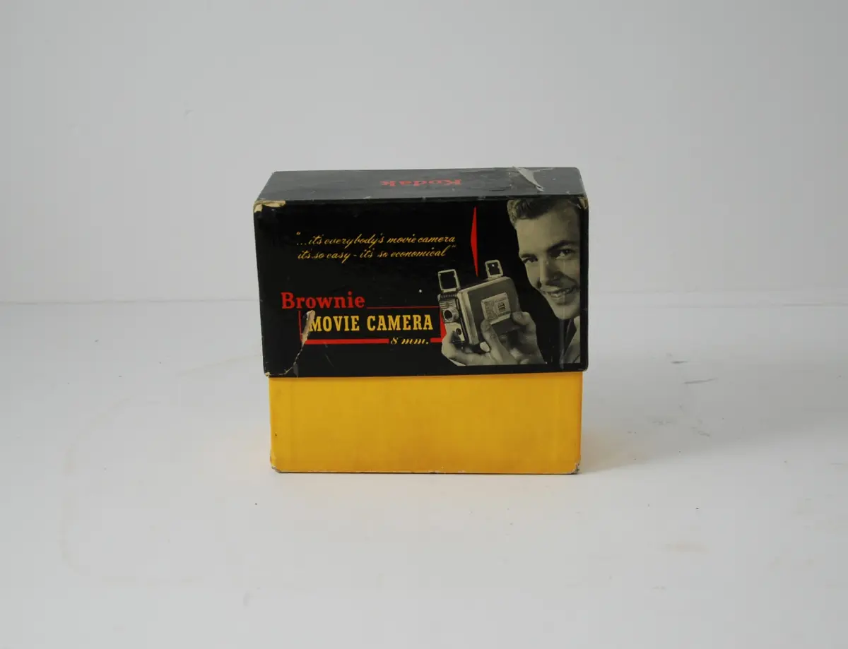 Form: rektangulær, bredere oppe enn nede, linse på kortside, sveiv for film på langside, knapper for blender etc.
