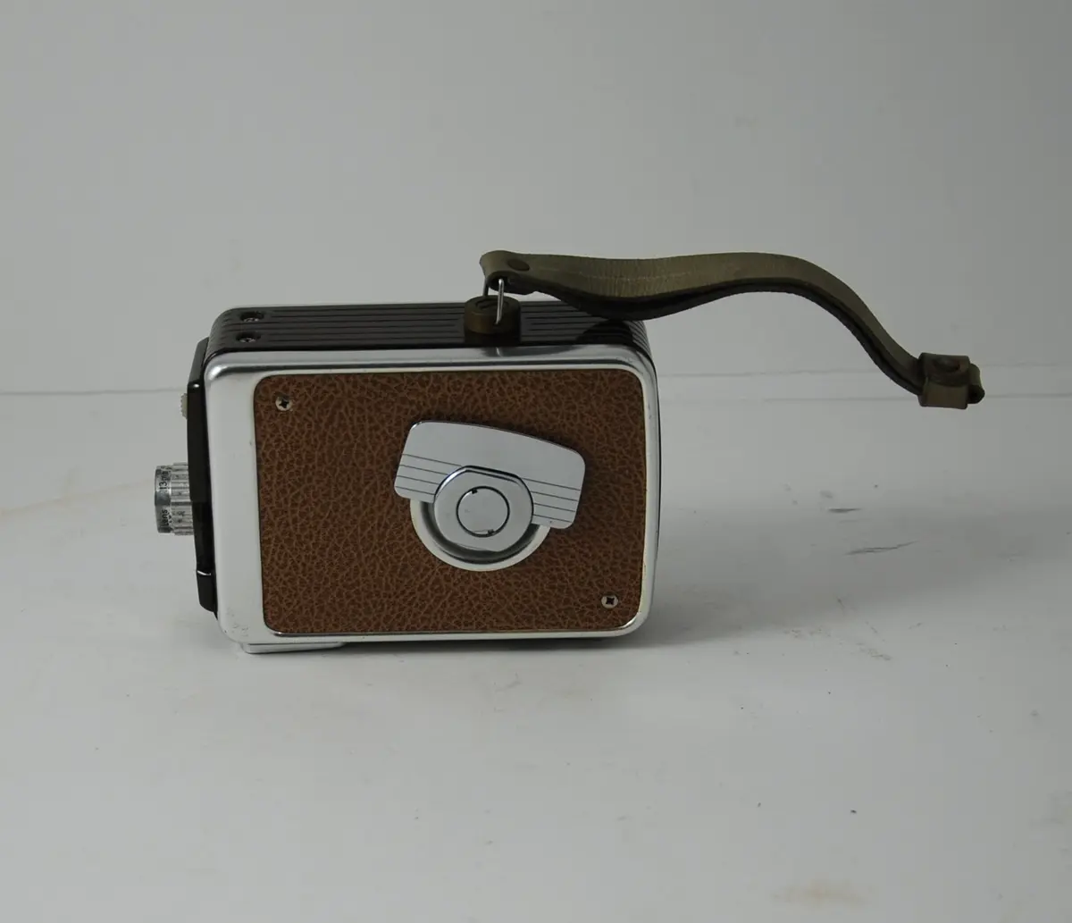 Form: rektangulær, bredere oppe enn nede, linse på kortside, sveiv for film på langside, knapper for blender etc.
