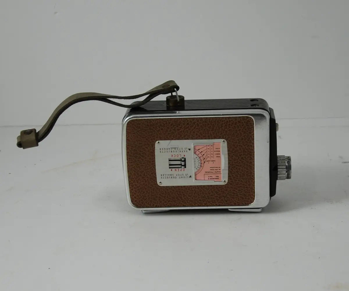 Form: rektangulær, bredere oppe enn nede, linse på kortside, sveiv for film på langside, knapper for blender etc.
