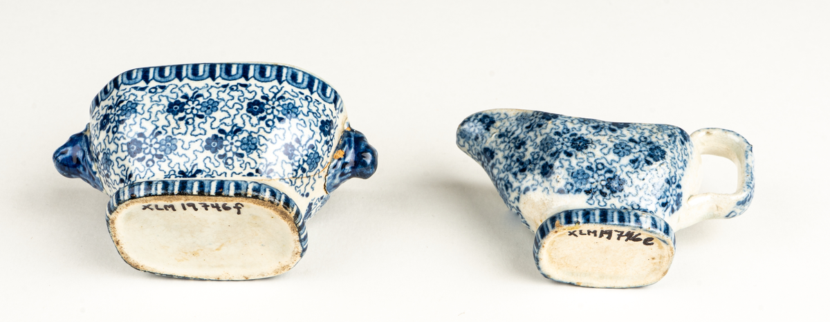 Fat, till dockservis. Ev flintgods. Glaserad. Vit med foralt mönster i blått. Ovalt. Vit och blå etikett.