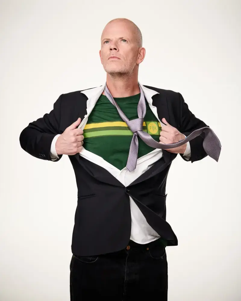 Bilete av Are Kalvo med svart dress, slips og Felleskjøpet-tskjorte.