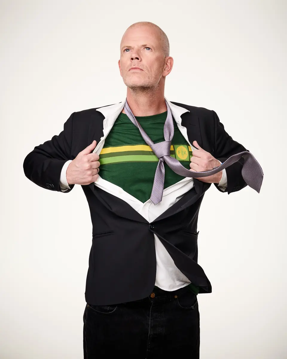 Bilete av Are Kalvo med svart dress, slips og Felleskjøpet-tskjorte.