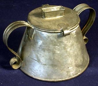 Svagt koniskt formad behållare med lock. I locket en rektangulär öppning med en kant runtomkring. Två handtag i form av på svetsade dekorativt bockade plåtstycken. Diameter i botten: 150 mm. Diameter på locket: 90 mm.

Nedstucken i bössans öppning en lapp på vilken det är skrivet för hand: "Kollektbössa av bleckplåt ca 1870. Böjs missionsförsamling, Östra Fågelvik".