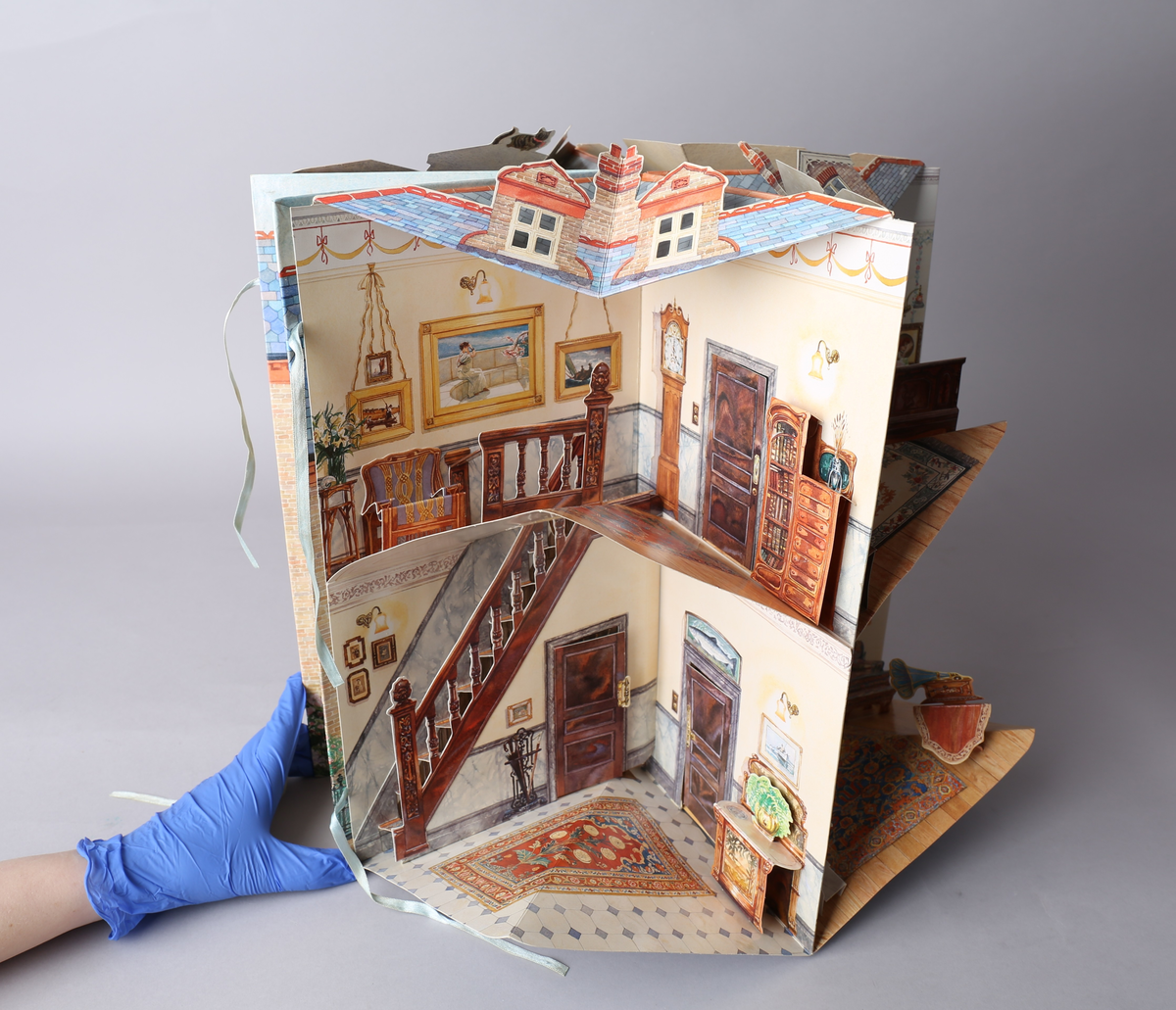 Dukkehus i form av en bok som brettes ut og blir et edvardiansk hus. Når utbrettet er det kvadratisk og blir et 360° graders dukkehus. Alle tak, vegger og gulv har påtegnet interiør, og noe av interiøret er brettet og pålimt, og skaper en 3D-effekt. Detaljene er intrikate, og det medfølger stansede figurer til å leke med. Av typen rom er foaje, spisestue, bad, soverom, formell stue eller musikkrom og kjøkken representert.