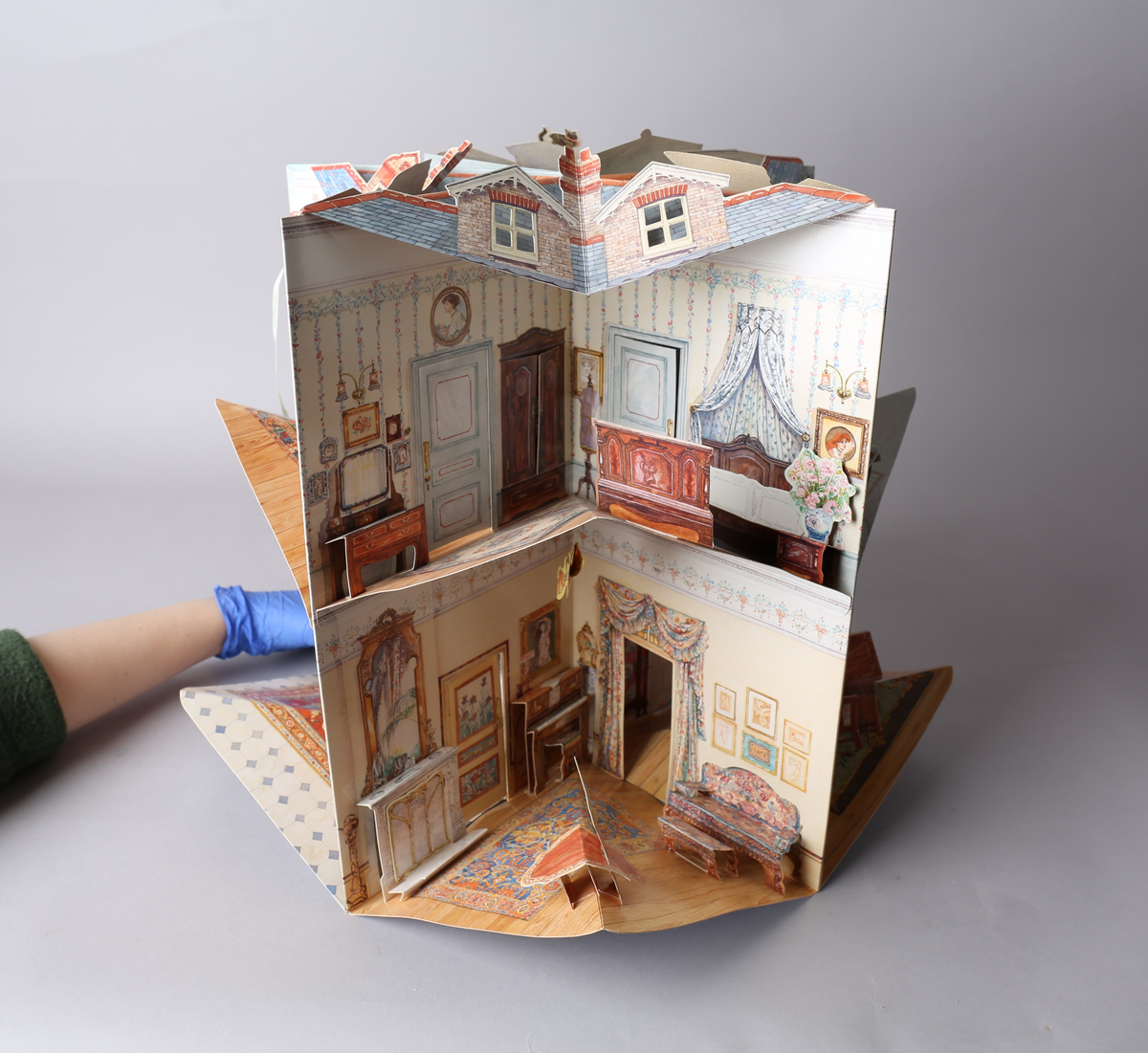 Dukkehus i form av en bok som brettes ut og blir et edvardiansk hus. Når utbrettet er det kvadratisk og blir et 360° graders dukkehus. Alle tak, vegger og gulv har påtegnet interiør, og noe av interiøret er brettet og pålimt, og skaper en 3D-effekt. Detaljene er intrikate, og det medfølger stansede figurer til å leke med. Av typen rom er foaje, spisestue, bad, soverom, formell stue eller musikkrom og kjøkken representert.