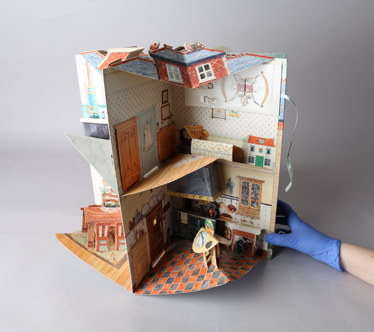 Dukkehus i form av en bok som brettes ut og blir et edvardiansk hus. Når utbrettet er det kvadratisk og blir et 360° graders dukkehus. Alle tak, vegger og gulv har påtegnet interiør, og noe av interiøret er brettet og pålimt, og skaper en 3D-effekt. Detaljene er intrikate, og det medfølger stansede figurer til å leke med. Av typen rom er foaje, spisestue, bad, soverom, formell stue eller musikkrom og kjøkken representert.