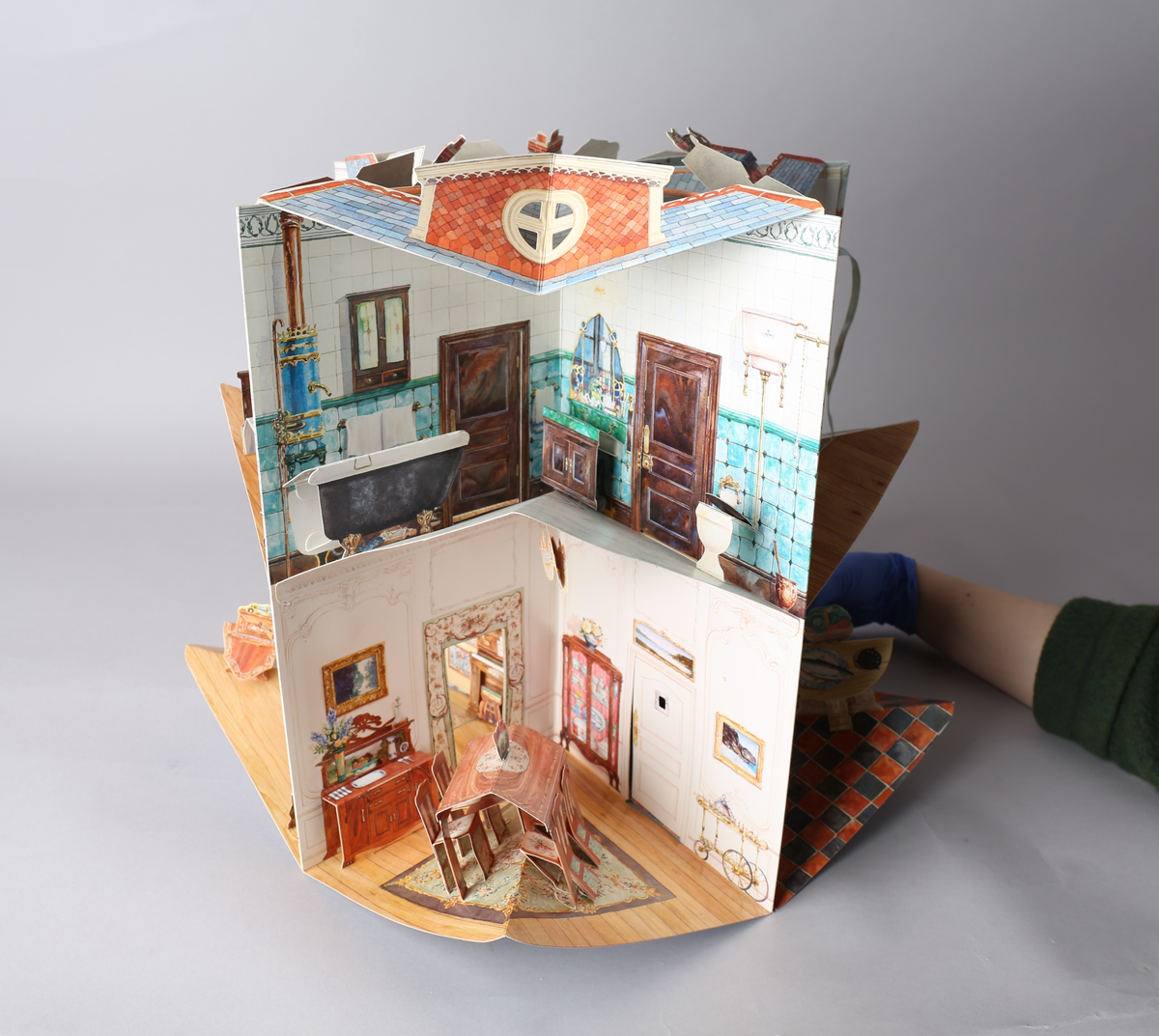 Dukkehus i form av en bok som brettes ut og blir et edvardiansk hus. Når utbrettet er det kvadratisk og blir et 360° graders dukkehus. Alle tak, vegger og gulv har påtegnet interiør, og noe av interiøret er brettet og pålimt, og skaper en 3D-effekt. Detaljene er intrikate, og det medfølger stansede figurer til å leke med. Av typen rom er foaje, spisestue, bad, soverom, formell stue eller musikkrom og kjøkken representert.