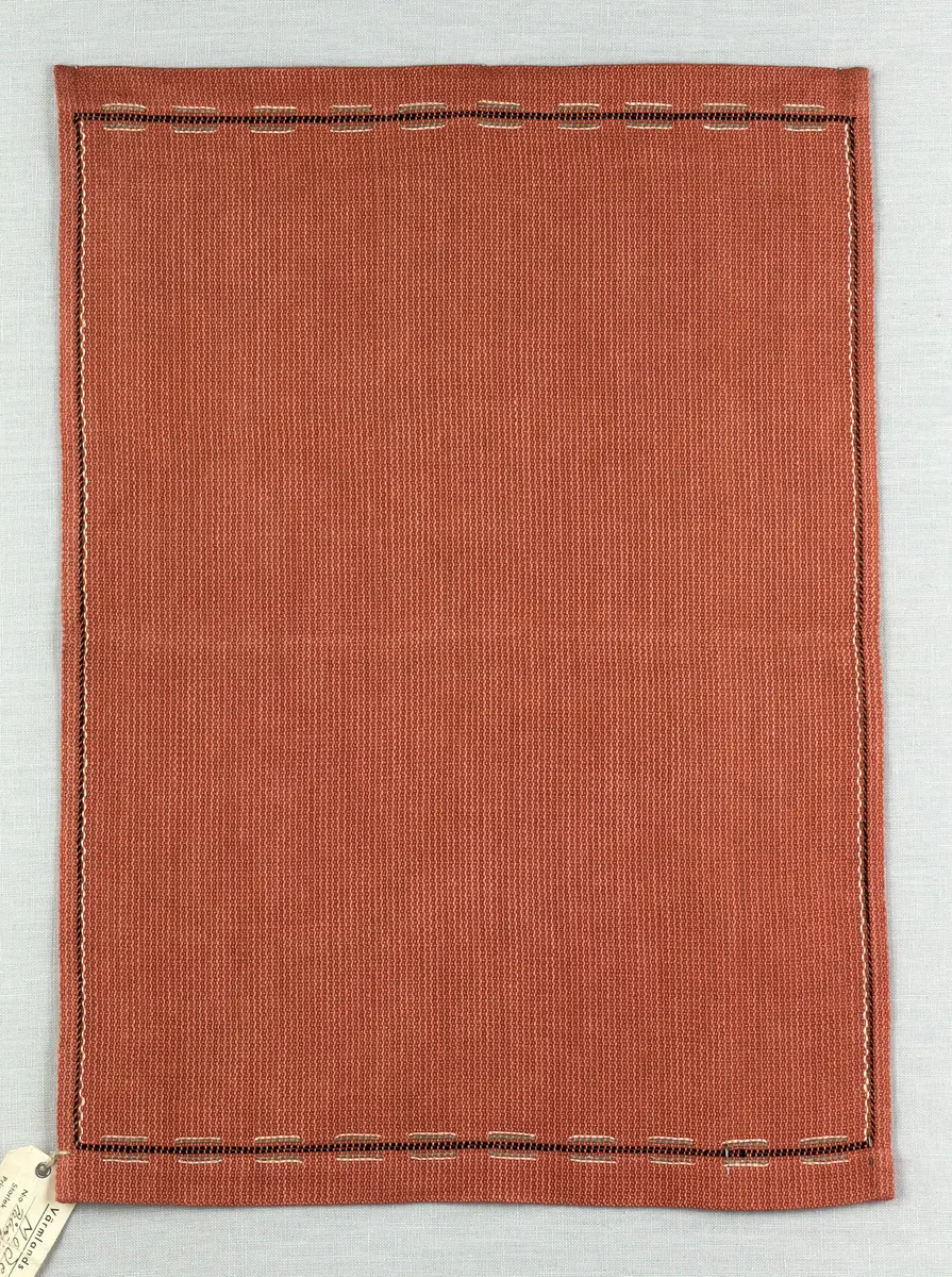 Tablett gjord av halvlinne i liksidig korskypert och broderi utfört med 2-trådigt lingarn i trädsöm. 
Dukens kortsidor har 18mm breda fållar och långsidorna 7mm, vilka är sydda med smygstygn. 