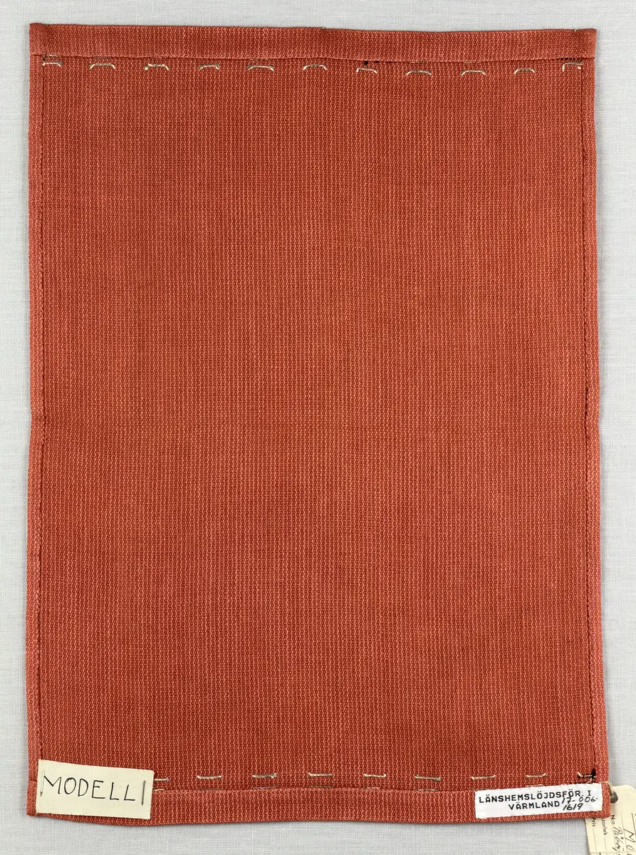 Tablett gjord av halvlinne i liksidig korskypert och broderi utfört med 2-trådigt lingarn i trädsöm. 
Dukens kortsidor har 18mm breda fållar och långsidorna 7mm, vilka är sydda med smygstygn. 